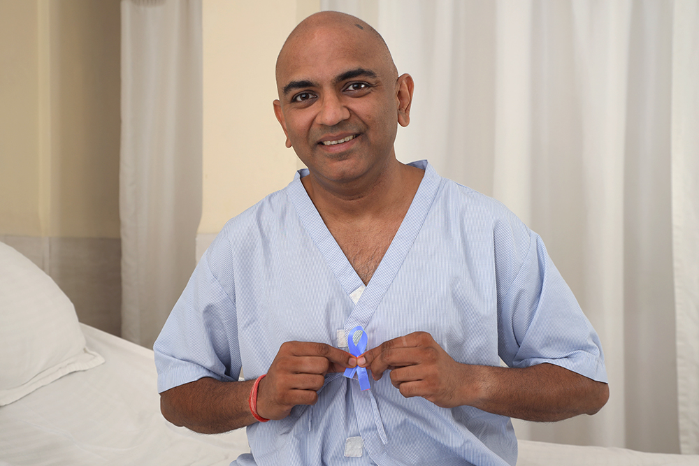 Man holding up a cancer ribbon.