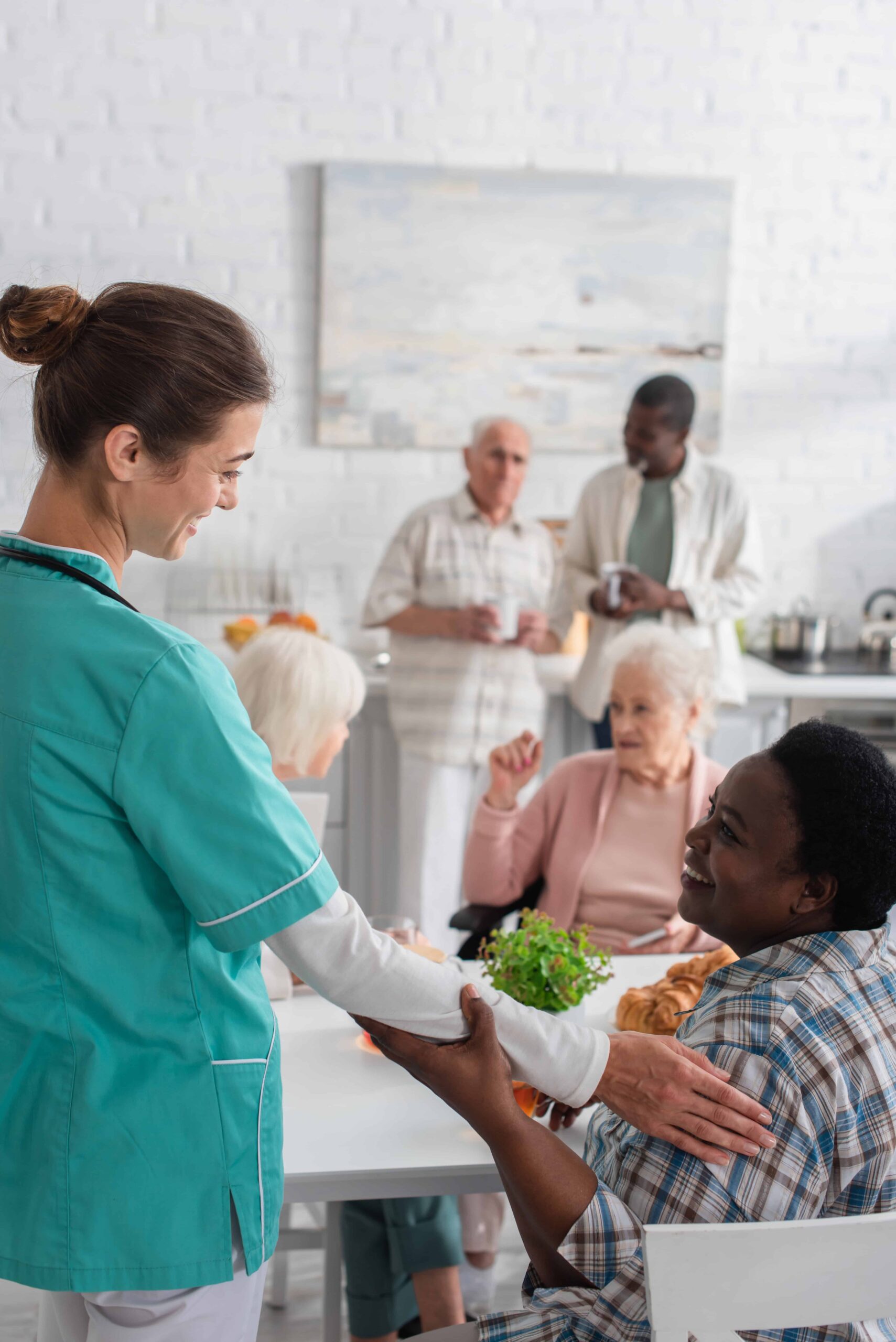 Smiling nurse touching elderly african american woman in nursing home