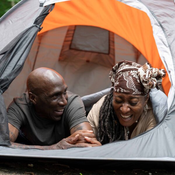 AdobeStock_625089854 Mature couple relaxing in gray and orange tent after hike